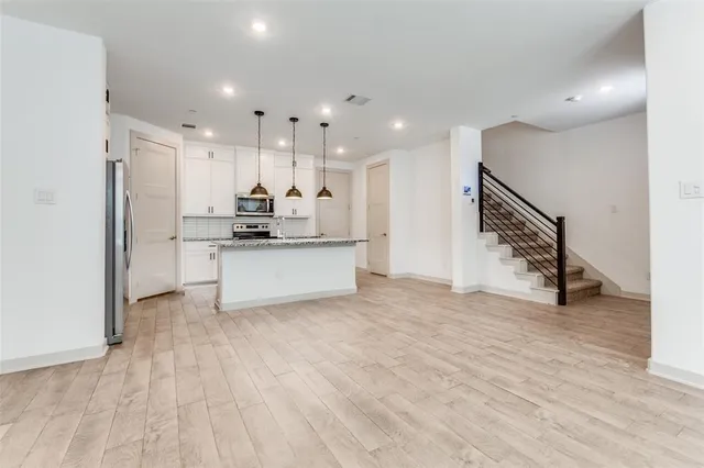 a kitchen with stainless steel appliances a refrigerator and a stove top oven