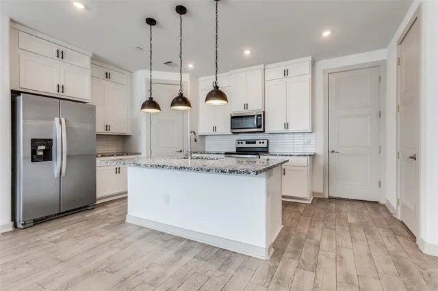 a kitchen with kitchen island a counter top space a sink and a refrigerator
