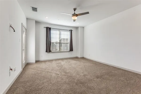 an empty room with windows and ceiling fan