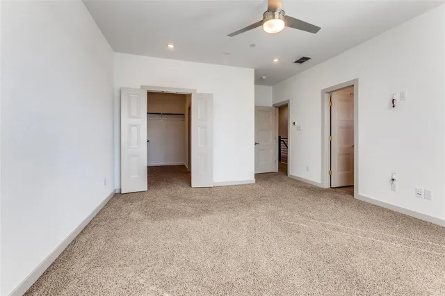an empty room with a ceiling fan and a window