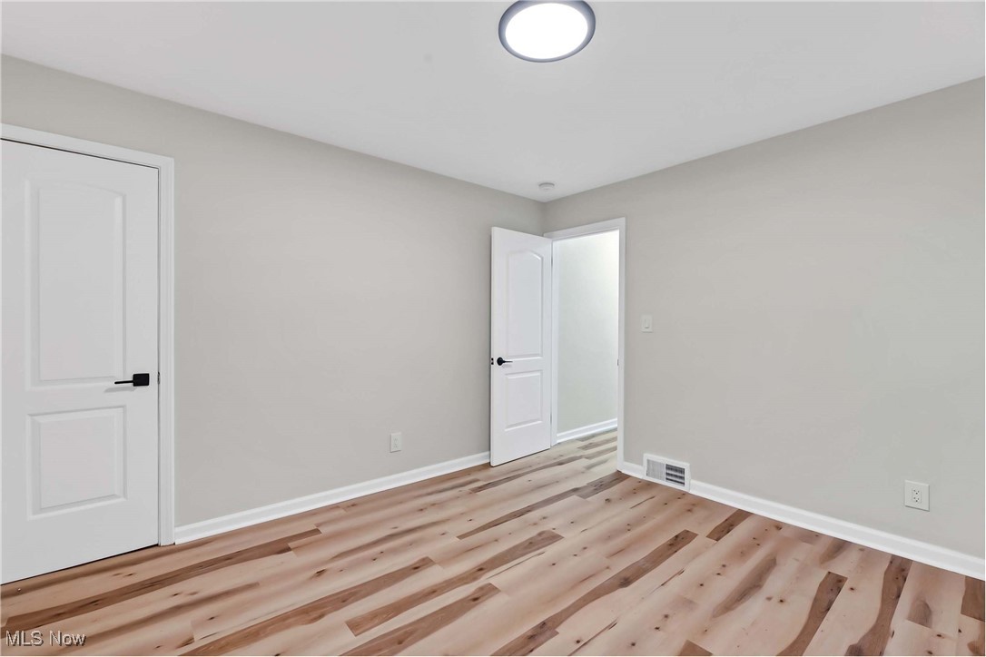 4209 Stilmore Road Cleveland, OH 44121 - Photo 21 of 36 Empty room with wood finished floors, baseboards, and visible vents