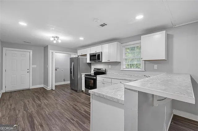 a kitchen with granite countertop a sink stove and refrigerator