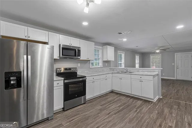 a kitchen with white cabinets and stainless steel appliances