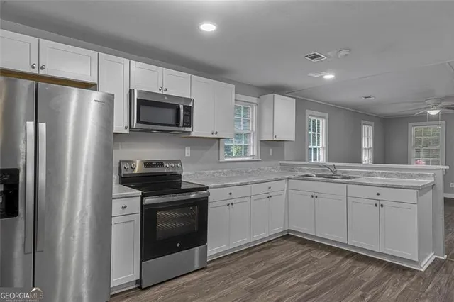 a kitchen with stainless steel appliances granite countertop a stove a sink and a refrigerator
