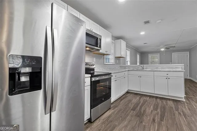 a kitchen with stainless steel appliances granite countertop a refrigerator and a stove top oven