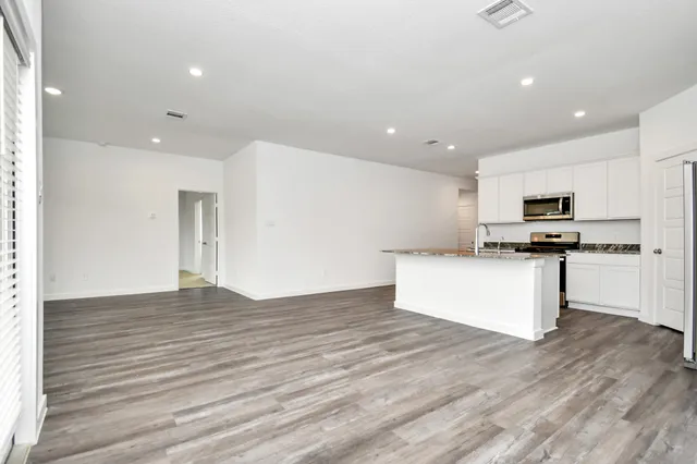 a kitchen with stainless steel appliances a refrigerator sink and white cabinets
