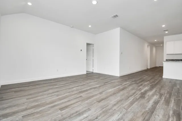 a view of empty room with wooden floor