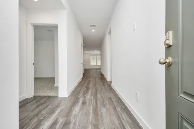 a view of a hallway with wooden floor