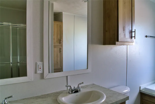 a bathroom with a sink a toilet and shower