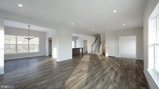 an empty room with wooden floor and a window