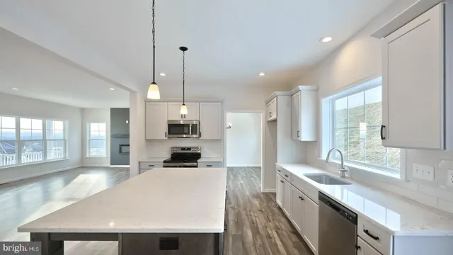 a large kitchen with kitchen island a large island a sink stainless steel appliances and cabinets