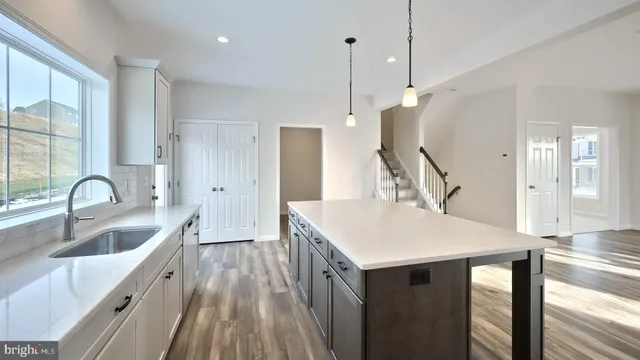 a kitchen with kitchen island a sink appliances and a counter top space