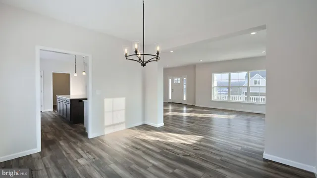 a view of empty room with wooden floor and window