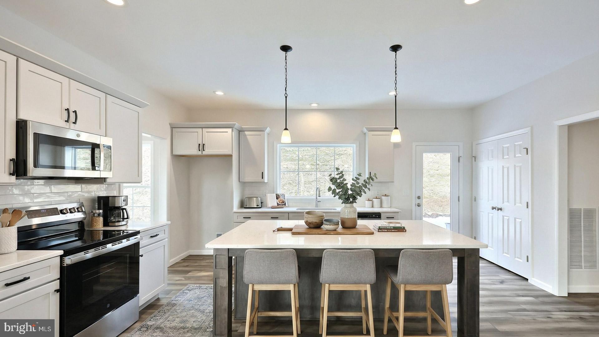 220 Copper Ridge Drive Newmanstown, PA 17073 - Photo 4 of 31 a kitchen with stainless steel appliances kitchen island granite countertop a sink a stove a dining table and chairs