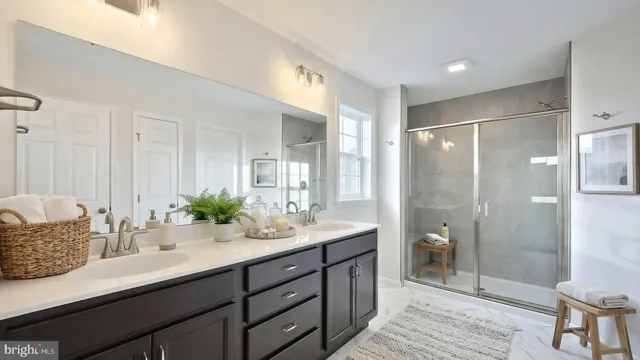 a en suite bathroom with a granite countertop sink mirror and shower