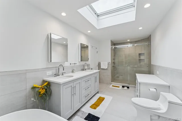 a bathroom with a sink a toilet a mirror and shower