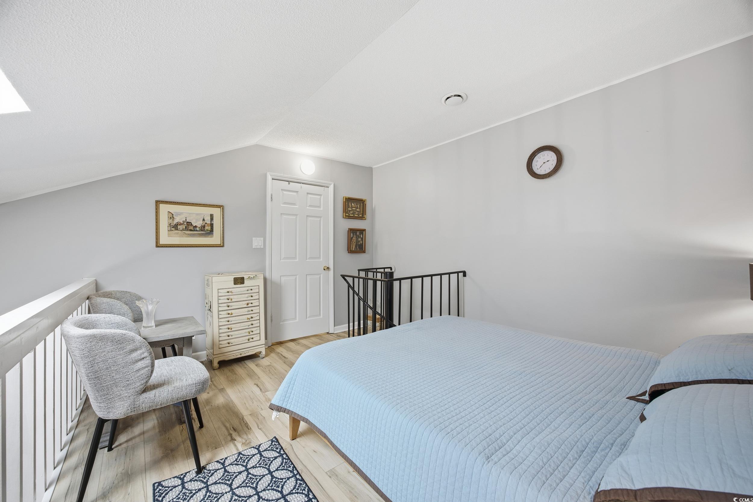 1200 Benna Drive, Unit 1C Myrtle Beach, SC 29577 - Photo 17 of 37 Bedroom with vaulted ceiling, light wood-style flooring, and a skylight