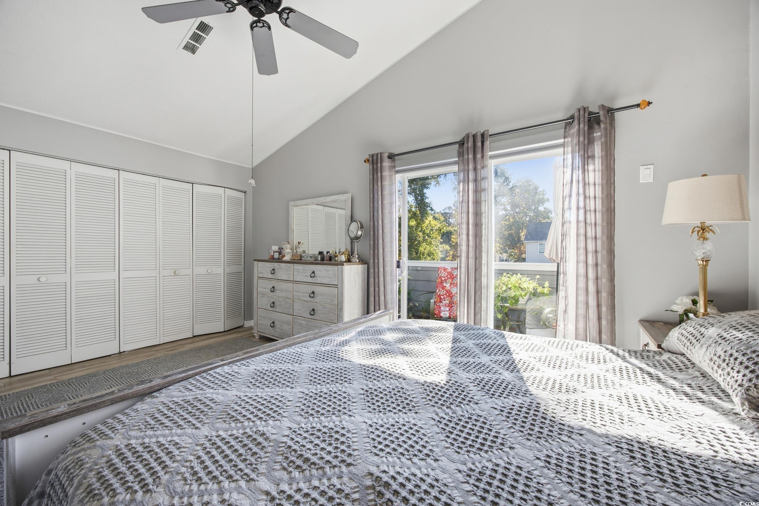 1200 Benna Drive, Unit 1C Myrtle Beach, SC 29577 - Photo 21 of 37 Bedroom with vaulted ceiling, a closet, ceiling fan, and access to exterior