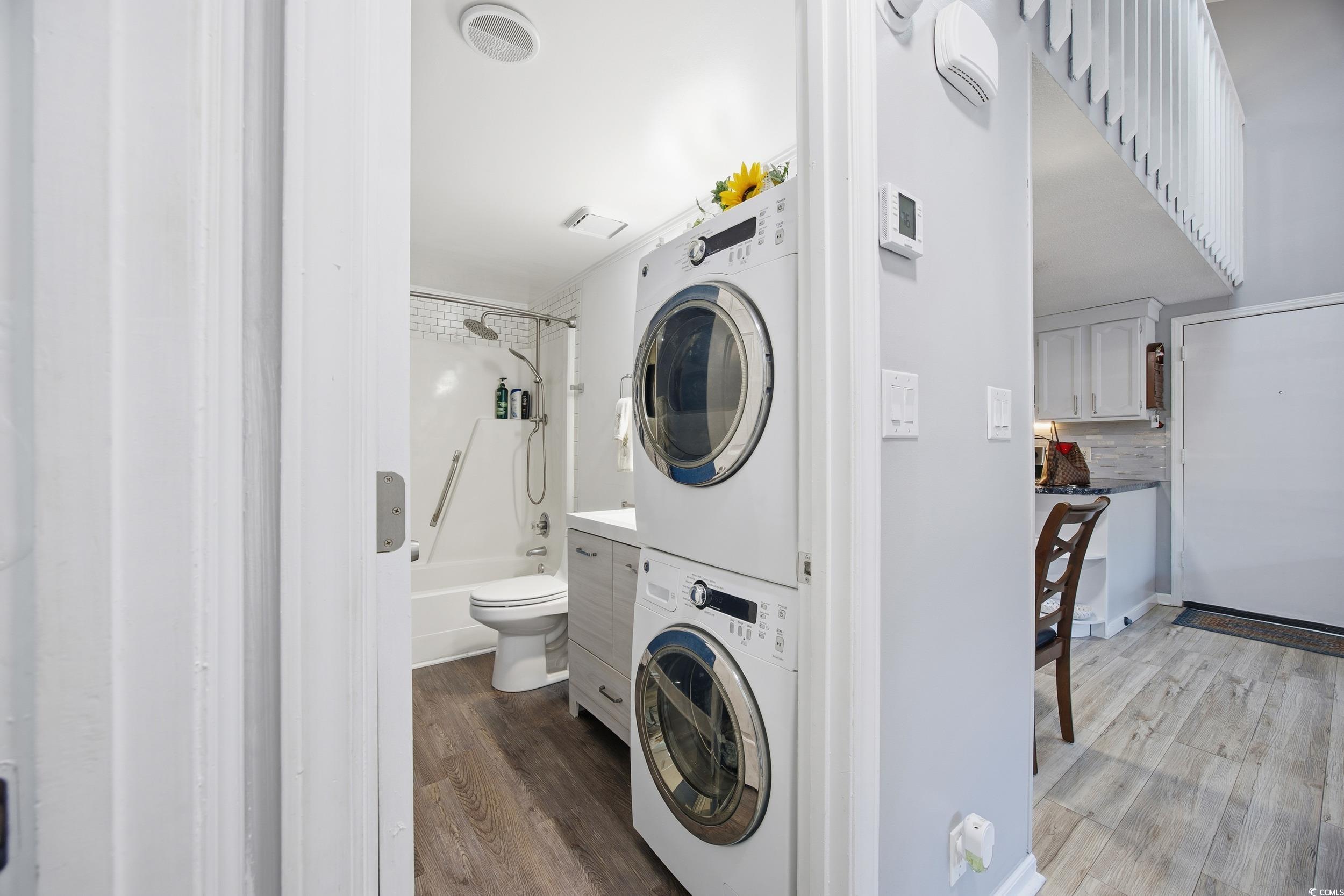 1200 Benna Drive, Unit 1C Myrtle Beach, SC 29577 - Photo 22 of 37 Laundry room featuring dark wood-style floors and stacked washing machine and dryer