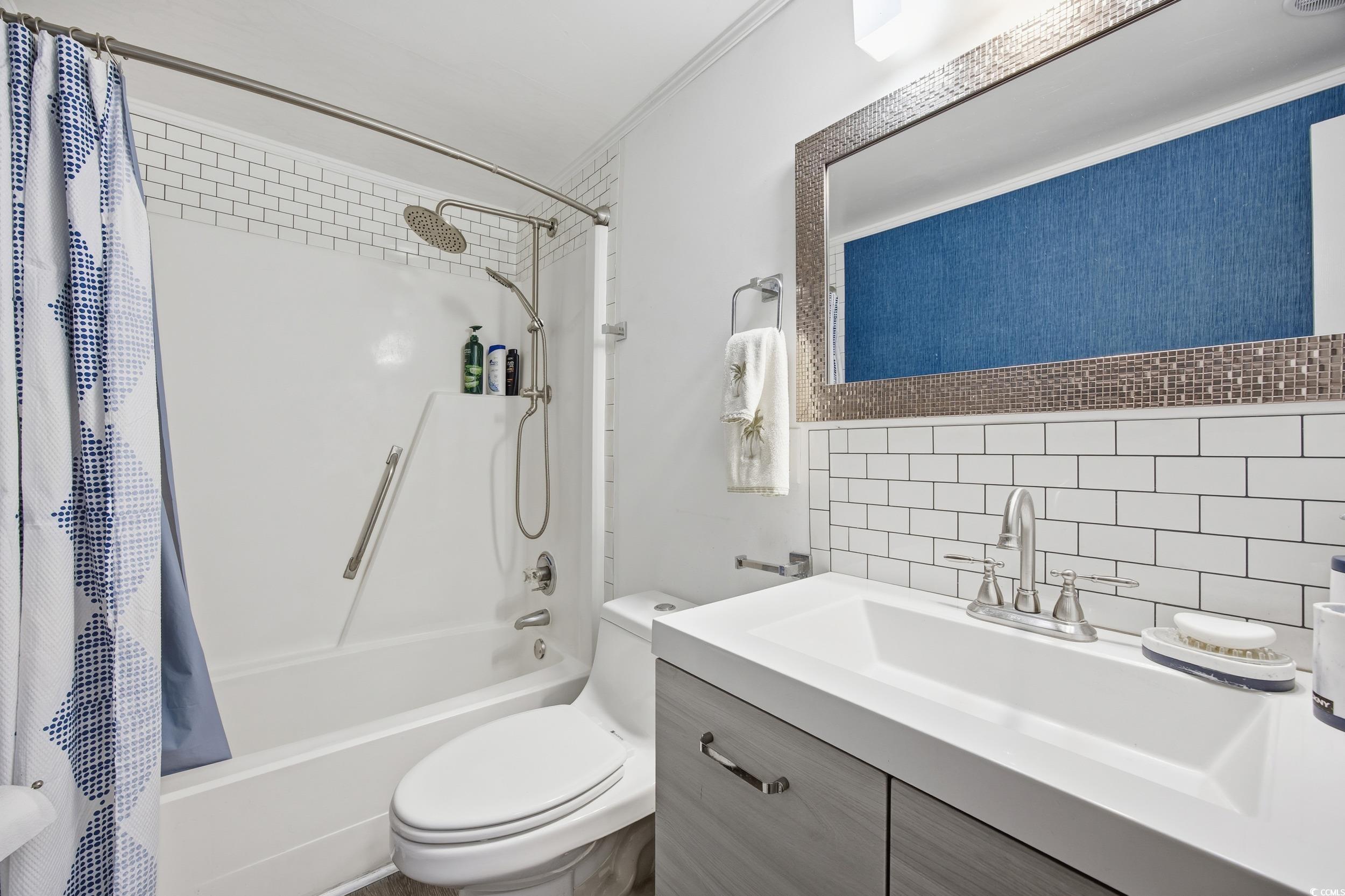 1200 Benna Drive, Unit 1C Myrtle Beach, SC 29577 - Photo 23 of 37 Full bathroom with vanity, shower / bath combination with curtain, tasteful backsplash, and ornamental molding