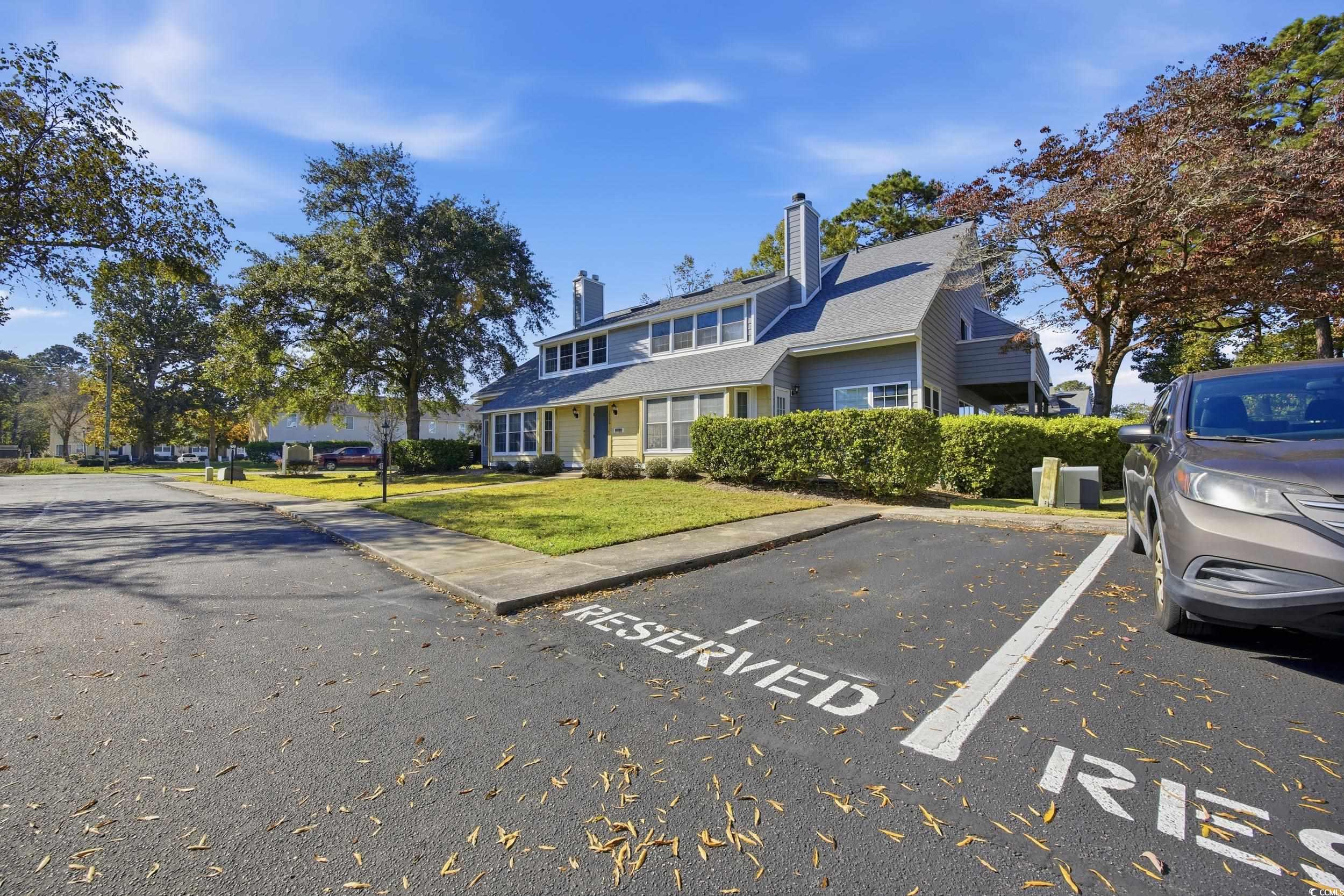 1200 Benna Drive, Unit 1C Myrtle Beach, SC 29577 - Photo 35 of 37 Traditional home featuring a chimney, uncovered parking, and a front lawn