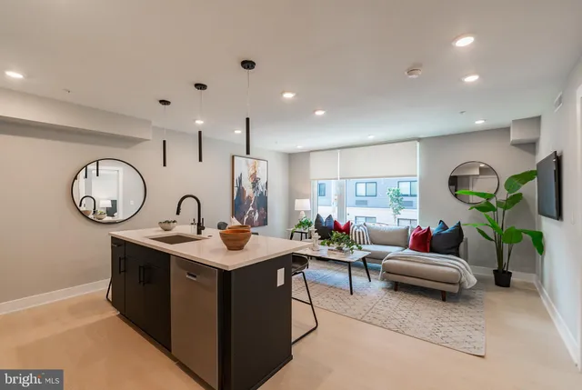 a living room with furniture a clock and white walls