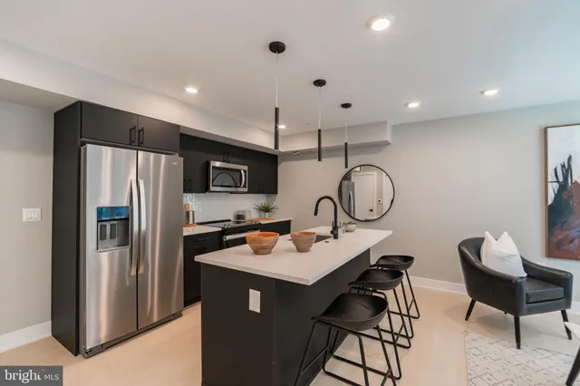 a kitchen with a refrigerator a sink and chairs