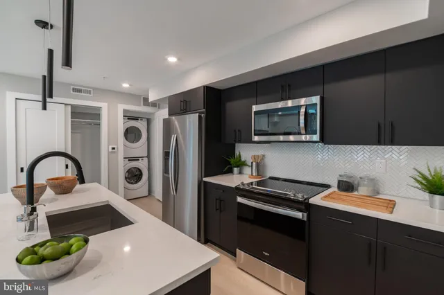 a kitchen with a refrigerator and a stove top oven