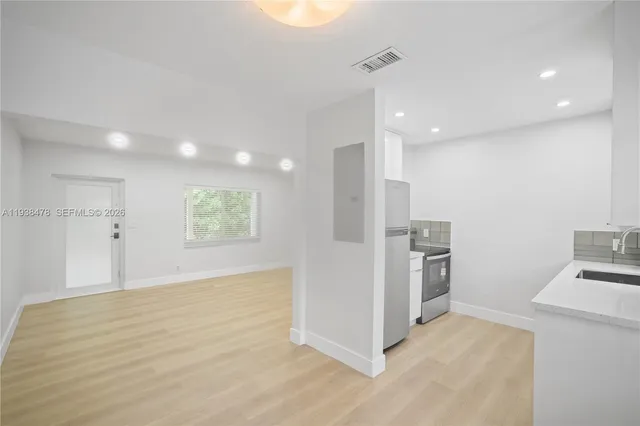 a view of a kitchen with a sink refrigerator and a stove top oven