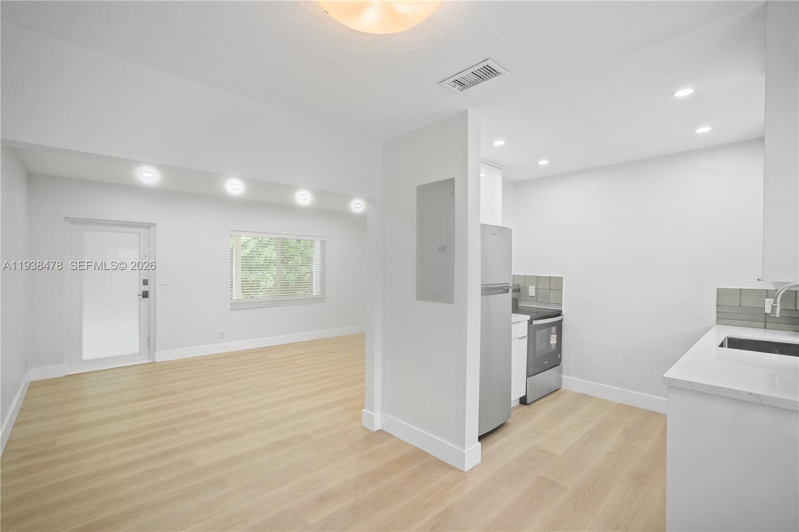a view of a kitchen with a sink refrigerator and a stove top oven