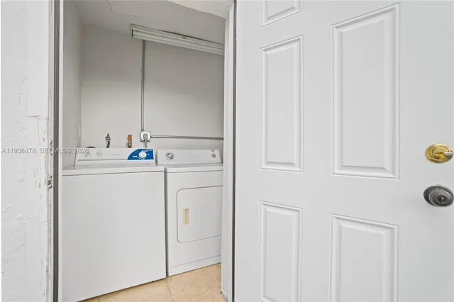 a utility room with cabinets washer and dryer