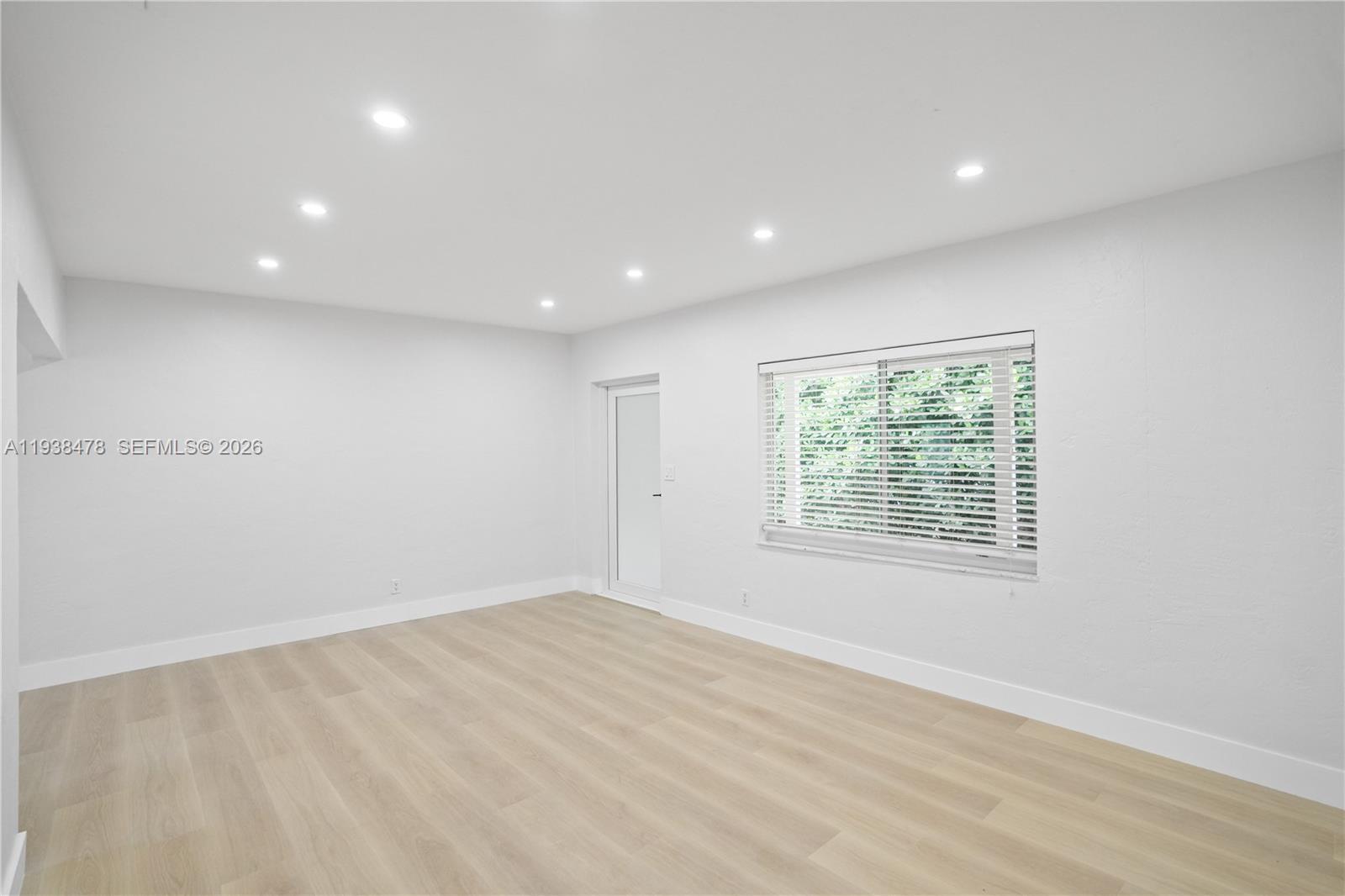 550 Northeast 68th Street, Unit 550 Miami, FL 33138 - Photo 6 of 15 an empty room with wooden floor and windows