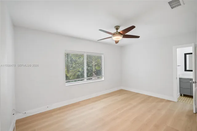 an empty room with a window and a fan