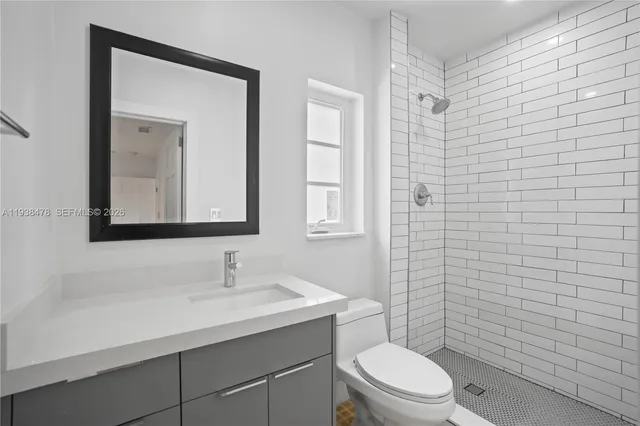 a bathroom with a toilet a sink a shower and mirror