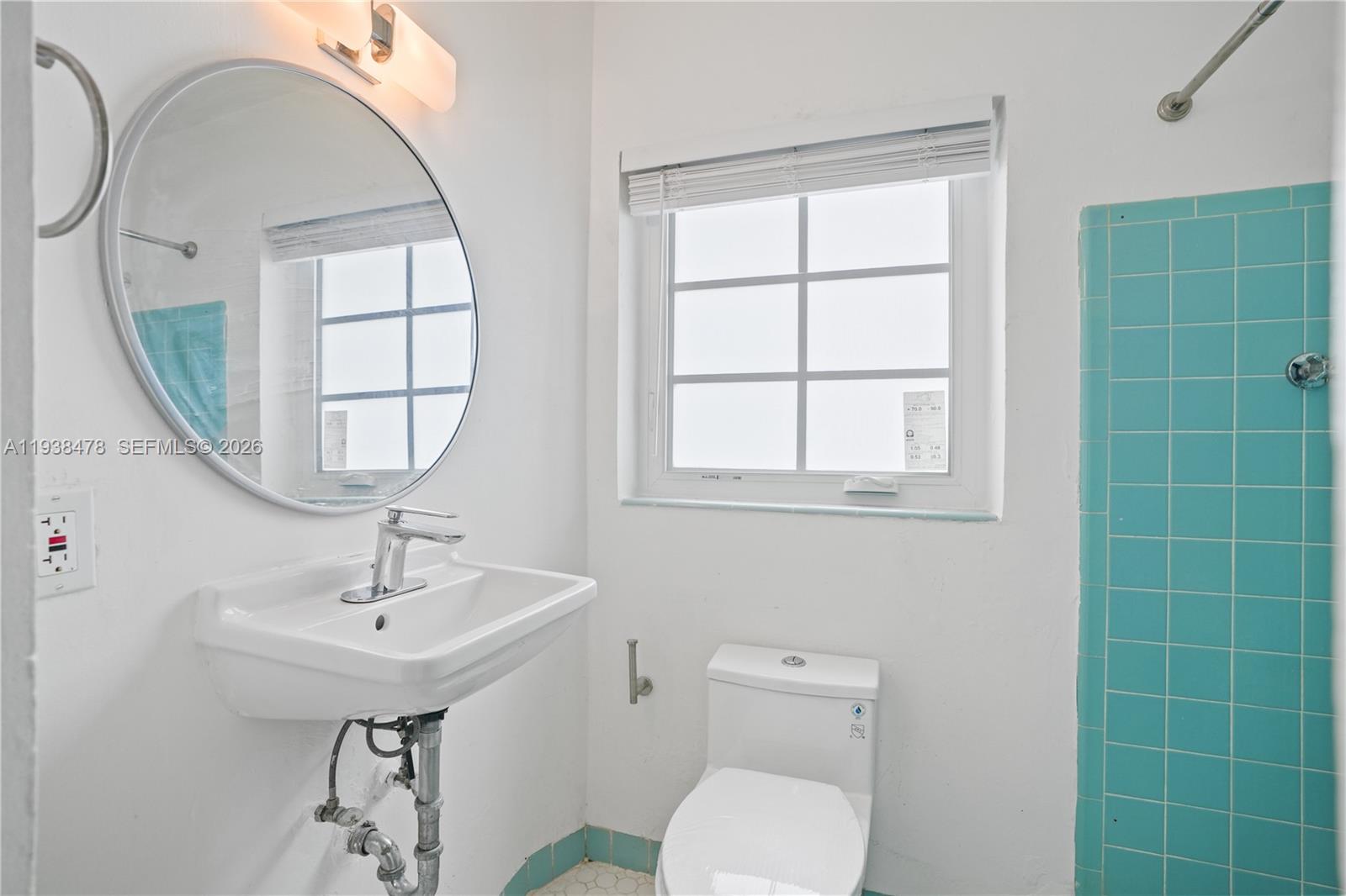 550 Northeast 68th Street, Unit 550 Miami, FL 33138 - Photo 10 of 15 a bathroom with a toilet a sink a window and mirror