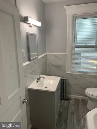 a bathroom with a sink toilet and mirror