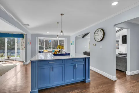 a kitchen with a wooden floor and a clock on the wall