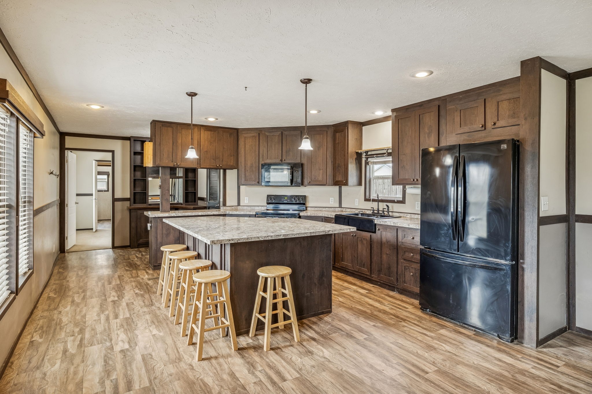3118 McKibbon Road Culleoka, TN 38451 - Photo 7 of 31 a kitchen with kitchen island a refrigerator a stove a sink and a dining table with wooden floor