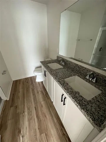 a bathroom with a granite countertop sink a large mirror and toilet