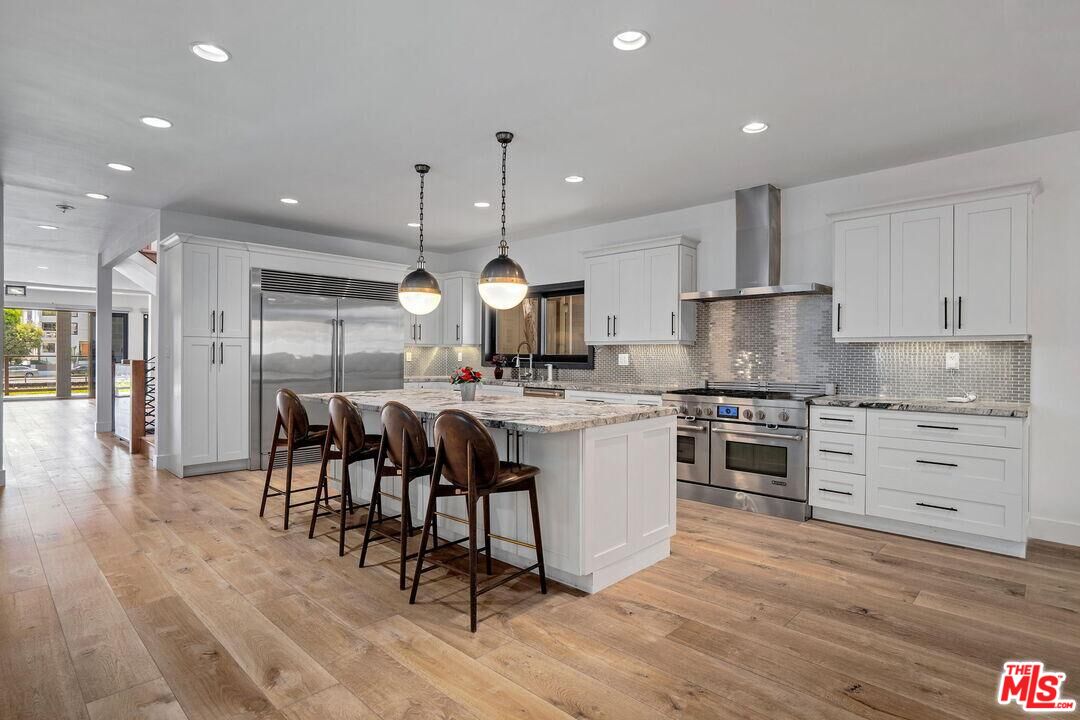 4811 Roma Court Marina del Rey, CA 90292 - Photo 24 of 57 a kitchen with stainless steel appliances kitchen island granite countertop a stove a sink and a refrigerator