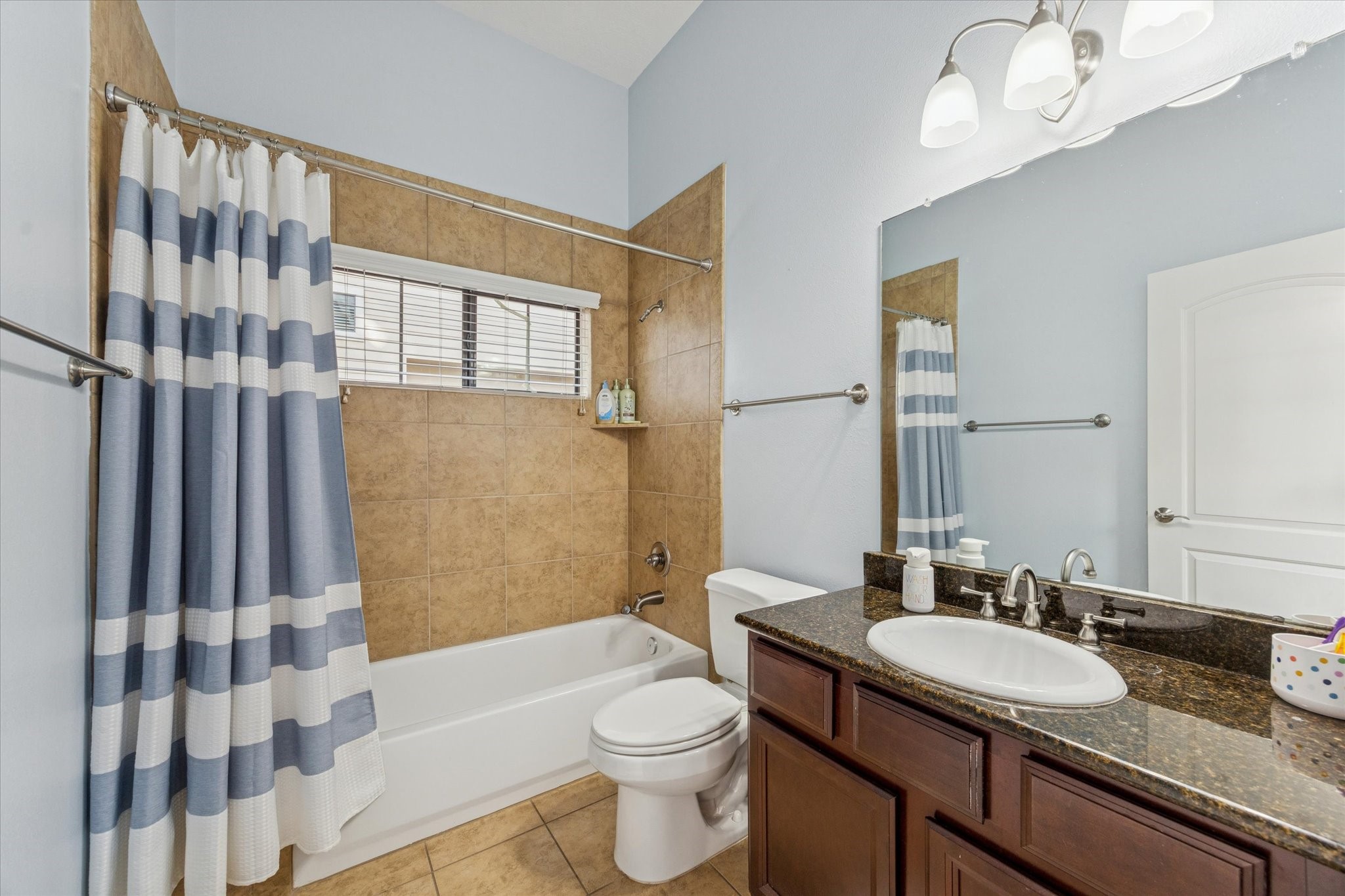3203 Garden Oaks View Houston, TX 77018 - Photo 12 of 13 a bathroom with a granite countertop sink a toilet a mirror a bathtub and shower