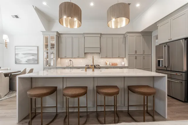 a kitchen with stainless steel appliances granite countertop a table chairs stove and refrigerator