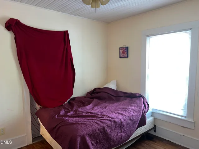 a bed sitting in a bedroom next to a window