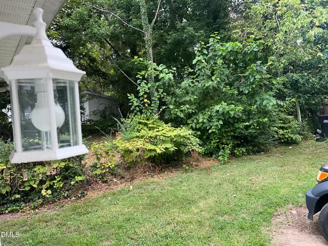 a front view of a house with a yard and potted plants