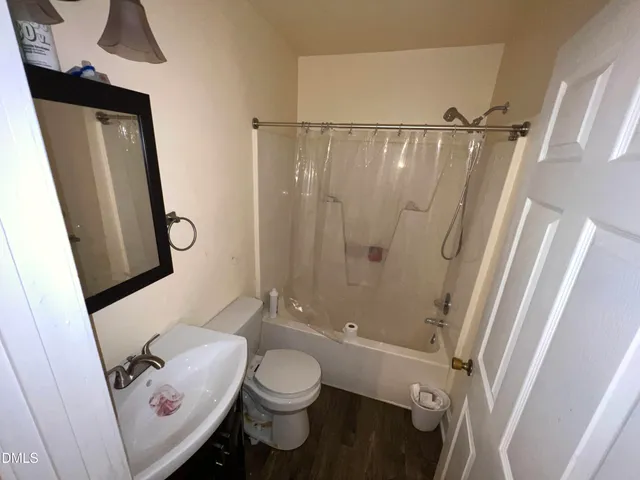 a bathroom with a sink a toilet a mirror and shower