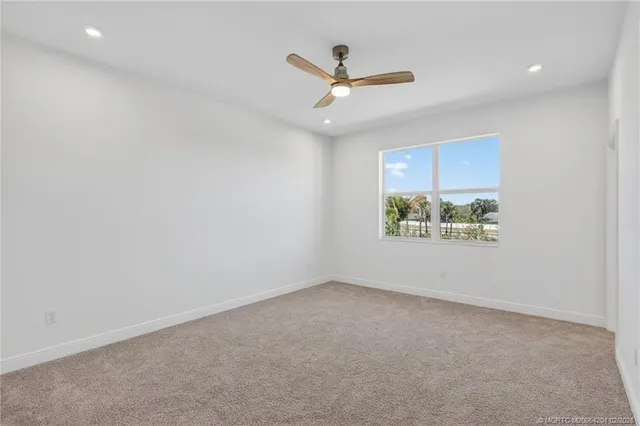 an empty room with closet and a ceiling fan