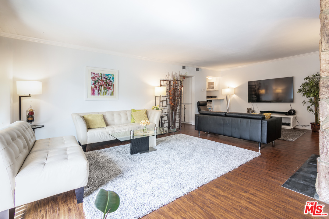1242 South Barrington Avenue, Unit 209 Los Angeles, CA 90025 - Photo 1 of 17 a living room with furniture and a flat screen tv