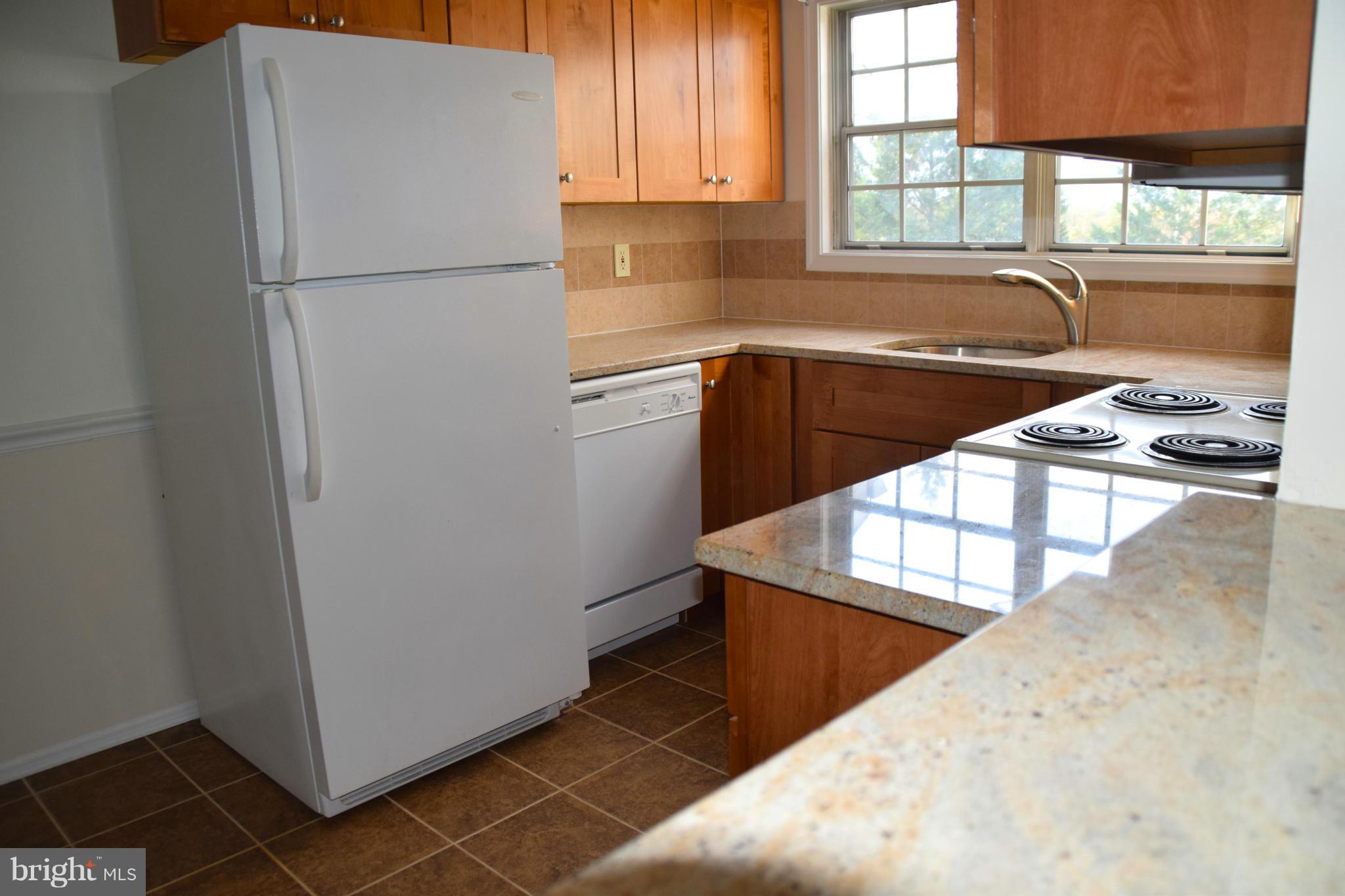 119 Fort Evans Road Southeast, Unit E Leesburg, VA 20175 - Photo 9 of 29 a kitchen with a refrigerator a stove a sink and a window
