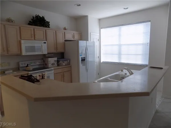 a kitchen with a refrigerator a stove a sink and a window