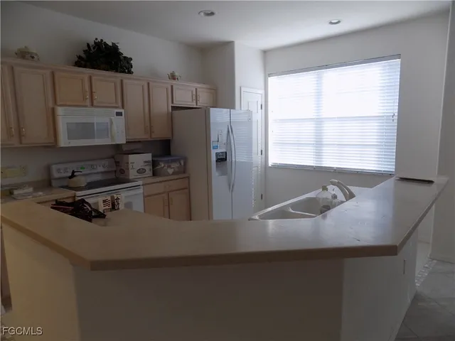 a kitchen with a refrigerator a stove a sink and a window